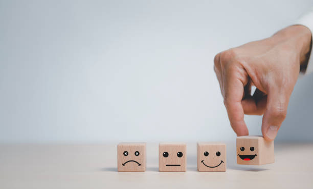 istock Customer service evaluation and satisfaction survey service rating concepts.Hand choose wooden cube block with icon face smile, Close up customer hand choose the happy face smile face icon on wooden. 1429073722