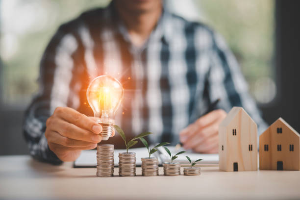 istock Businessman hand holding light bulb and leaf on  coins stack on the wooden table , Saving ideas and investment budget, Creative ideas concept of saving money  concept, Copy space 1429073892