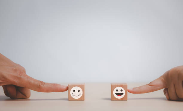 istock Customer service evaluation and satisfaction survey service rating concepts.Hand choose wooden cube block with icon face smile, Close up customer hand choose the happy face smile face icon on wooden. 1429074486