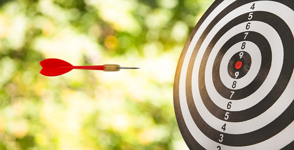 New Target and goal as concept, Close up shot of the dart arrow hit on bullseye, red dart arrow hitting in the target center of dartboard Target hit in the center, challenge in business marketing.