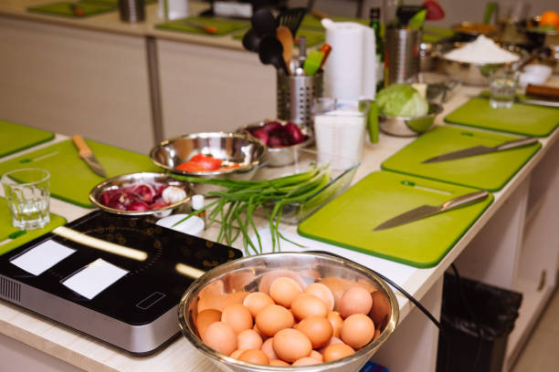 istock Cooking tables (working stations) prepared before the cooking master class. Cutting boards, raw food, kitchen utensils. 1429076564