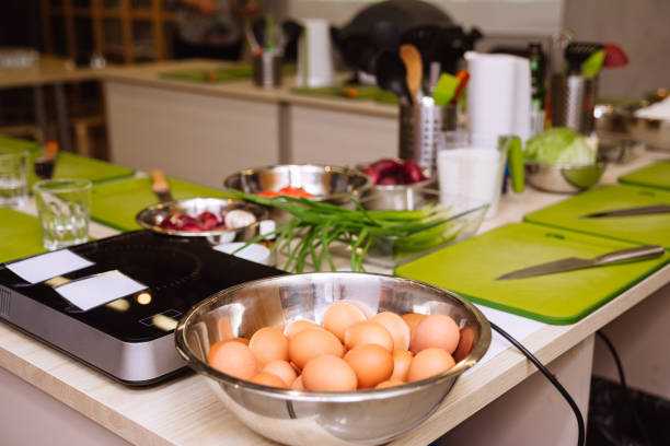 istock Cooking tables (working stations) prepared before the cooking master class. Cutting boards, raw food, kitchen utensils. 1429076573