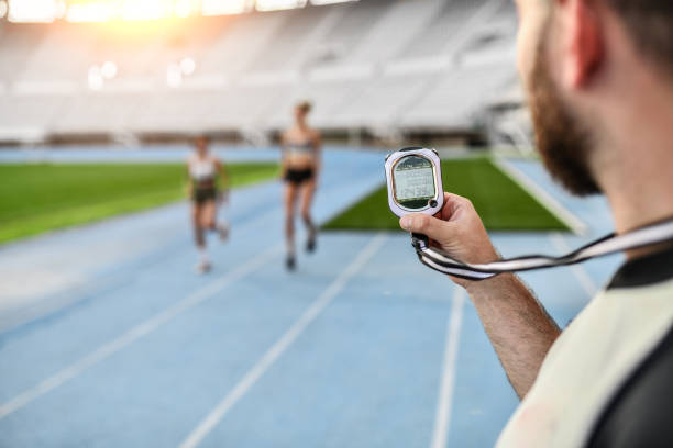 istock Athletic Females Race On Track While Coach Measures Time 1429082188