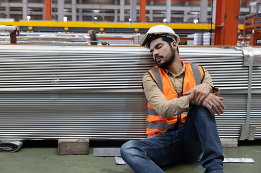 Tired Industrial Worker Take a Nap in a Factory