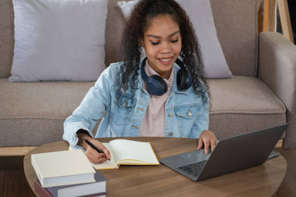istock African woman, American, using laptop computer and wearing headphones for online learning. 1429090080