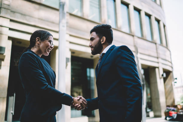 istock Smart colleagues shaking hands in city 1429097218