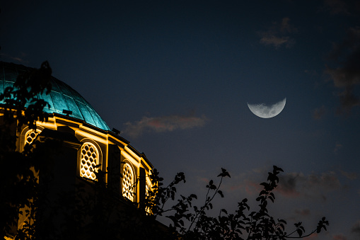 Blue domed mosque and half moon.Cloudy sky blue hour