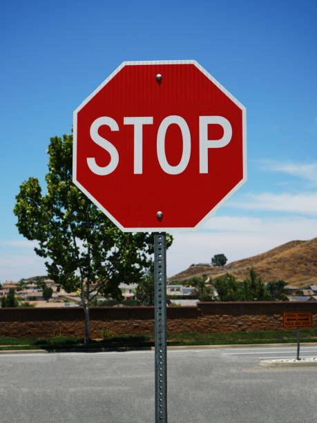 istock An octogonal red stop sign with street and trees. 1429112761