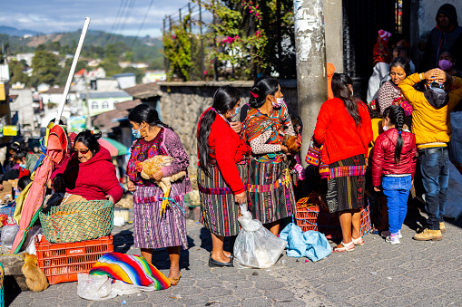 A few traditionally dressed women standing in line to sell their chicken and roosters at the market in Chichicastenango, Guatemala