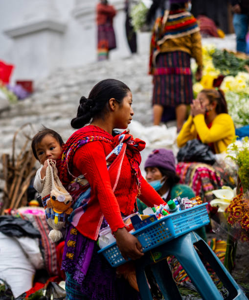 женщина с ребенком продает товары на рынке в чичикастенанго - guatemalan culture central america mother traditional culture стоковые фото и изображения