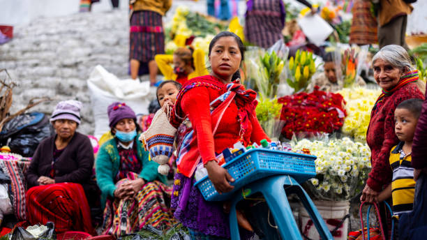 женщина с ребенком продает товары на рынке в чичикастенанго - guatemalan culture central america mother traditional culture стоковые фото и изображения