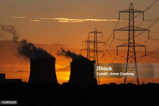 Silhouette Of A Power Stations Cooling Towers Against A Beautiful Autumn Sunset Near Drax In North Yorkshire Uk With Electricity Pylons And Plumes Of Water Vapour Rising From The Cooling Towers Stock Photo - Download Image Now