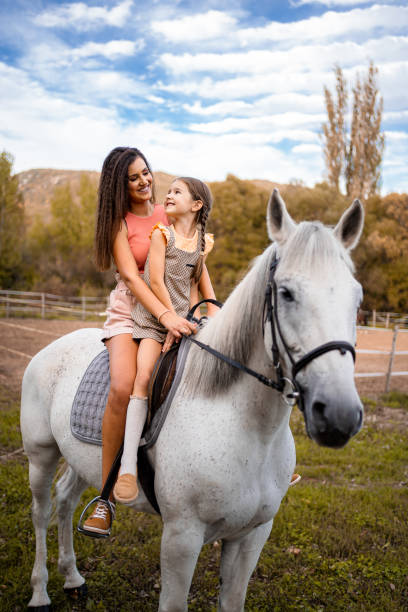 istock Mother teaching her daughter to ride a horse 1429128102