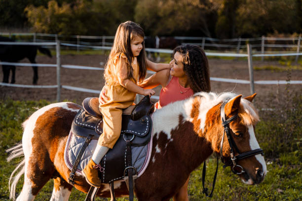 istock Mother teaching her daughter how to ride a pony 1429128167