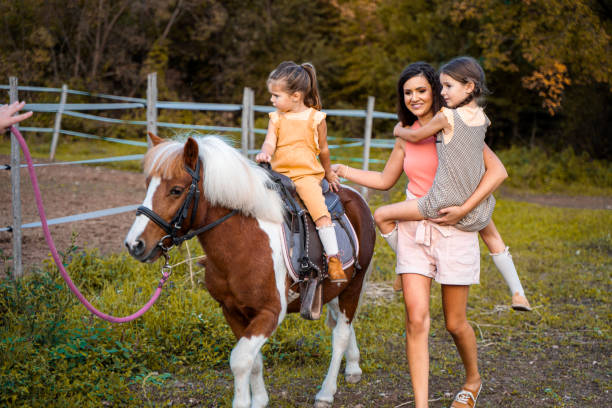 istock Mother with two little daughters at the horse ranch 1429128236