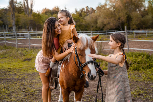istock Mother with two little daughters at the horse ranch 1429128302