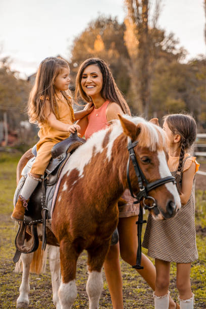 istock Mother with two little daughters at the horse ranch 1429128334