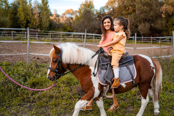 istock Mother teaching her daughter how to ride a pony 1429128372