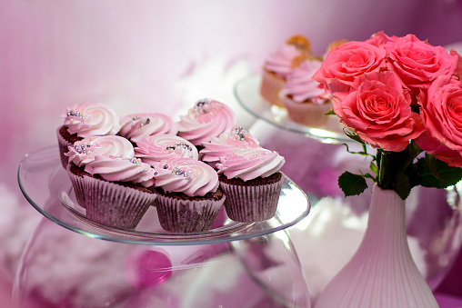 Table with cupcakes in pink color for party. Candy bar.