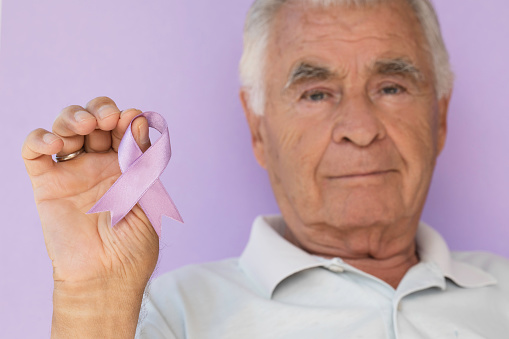 Senior man holding purple awareness ribbon. 

Purple awareness ribbon typically represents pancreatic cancer and epilepsy. Plus Alzheimer’s disease, lupus, Crohn’s disease, cystic fibrosis, fibromyalgia, sarcoidosis awareness, thyroid cancer, Attention Deficit Disorder (ADD).