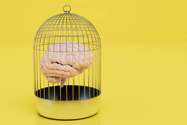 istock inability to think normally. brain in a cell on a yellow background. copy paste, copy space. 3D render 1429130490