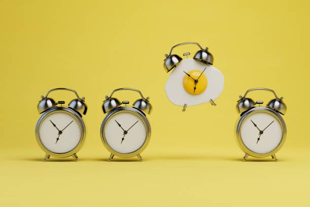 istock time for breakfast. old alarm clock and alarm clock with scrambled eggs on a yellow background. 3D render 1429133604