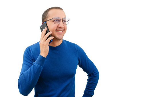 Young man in glasses uses a smartphone to make a call on a white background.