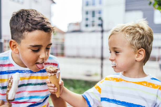 istock Toddler boy sharing his ice cream with his older brother 1429135757