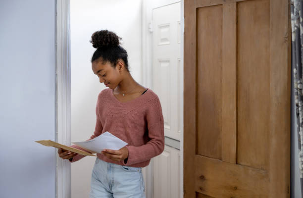 Teenage girl checking the mail while waiting for her college application Black teenage girl checking the mail while waiting for her college application - education concepts london girl stock pictures, royalty-free photos & images