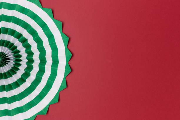 istock One green paper fan on a red background. 1429150619