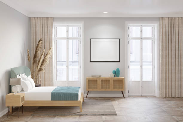 istock A bright bedroom with a blank horizontal poster on the wall between the balcony doors, decor on a wooden sideboard with a rattan door, spikelets near the bed, and a lamp on the bedside table. 1429151880
