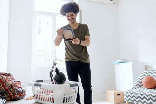 A student having fun unpacking and arranging things in a student's dorm room