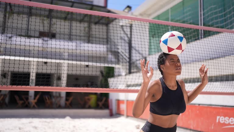 Instructor teaching a young woman in a footvolley class