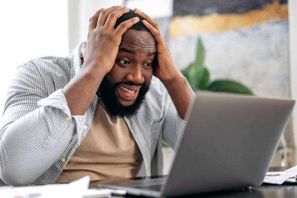 istock Irritated angry stressed african american man, sit at desk in the office, using laptop for online work, annoyed with bad result of his project, failed the deal, experiences negative emotions, stress 1429168320