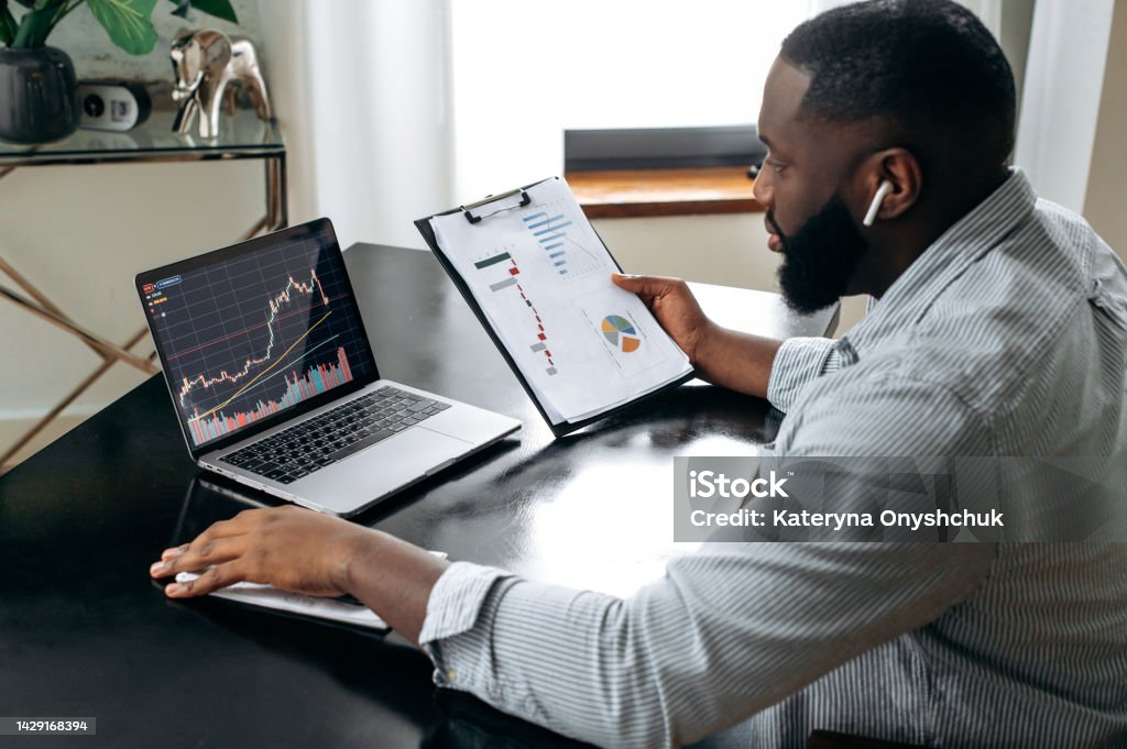 Successful crypto trader investor broker, using laptop for cryptocurrency financial market analysis, buying or selling cryptocurrency, analyzing financial diagrams on the screen Stock Market and Exchange Stock Photo