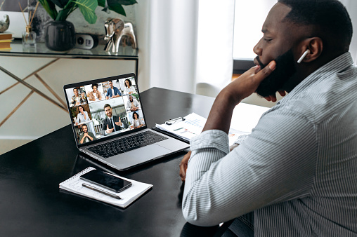 Group brainstorm. Smart african american man meet with a group of multiracial colleagues gathered in a video conference to communicate and discuss work issues and new project, planning business plan