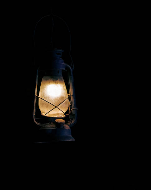 istock Vintage weathered lamp, dimly lit in the darkness ,isolated background. 1429170828