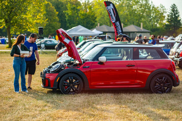 Oakville, Ontario, Canada- September 18, 2022.  MINI COOPER cars and fans on British Car Day show  in public park in suburb of Toronto, Canada. British Car Day is the largest British car show in North America. Over 1000 cars on display and 50 vendors. Held the 3rd Sunday of September at Bronte Park, Oakville, Ontario. Mini car has been around since 1959 and has been owned and issued by various car manufacturers.