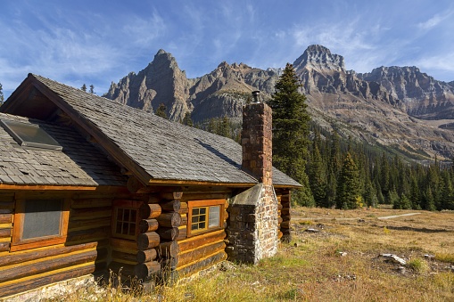 Vintage Rustic Wooden Log Cabin with High Canadian Rocky Mountain Peak Landscape, BC Yoho National Park