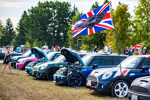 Oakville, Ontario, Canada- September 18, 2022.  MINI COOPER cars and fans on British Car Day show  in public park in suburb of Toronto, Canada. British Car Day is the largest British car show in North America. Over 1000 cars on display and 50 vendors. Held the 3rd Sunday of September at Bronte Park, Oakville, Ontario. Mini car has been around since 1959 and has been owned and issued by various car manufacturers.