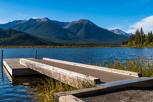 A floating, wooden dock into Vermillion Lake in Banff, Alberta, Canada on a sunny late summer day