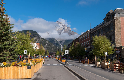 Banff, Alberta, Canada September 20, 2022 The Banff Avenue business district looking towards a clouded Cascade Mountain on a late, sunny summer day