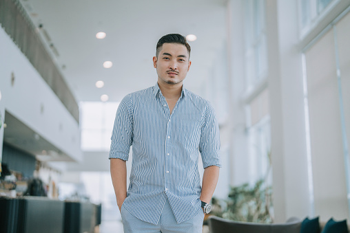 Asian Chinese Man business casual looking at camera smiling in office