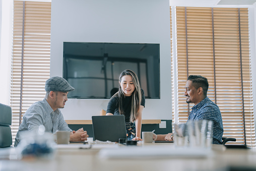 Asian Chinese woman leading confidently in conference room meeting with her colleague business planning discussion