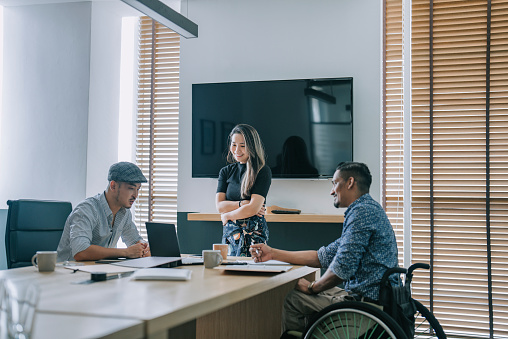 Asian Chinese woman leading confidently in conference room meeting with her colleague business planning discussion