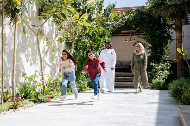 istock Competitive siblings racing outside their modern Saudi home 1429191490