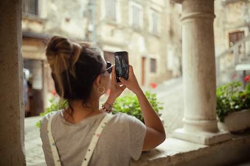 Back view of a woman photographing the architecture of the old town