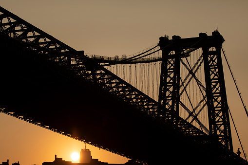 Silhouette view of the Williamsburg Bridge at sunset in NYC