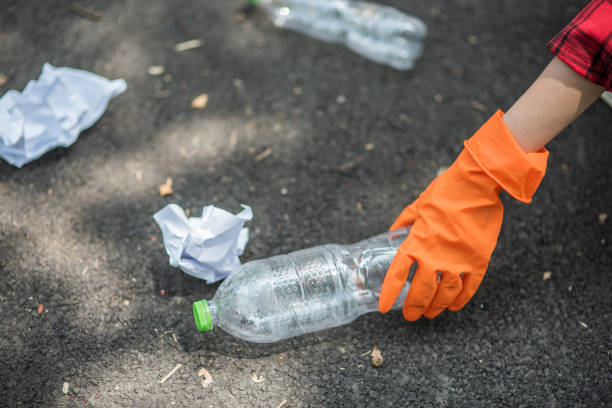 istock woman collecting garbage in a black bag. 1429219031