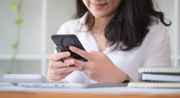 istock Young woman sitting in bright office and using smart phone for internet banking online or communicating on social network. 1429224407